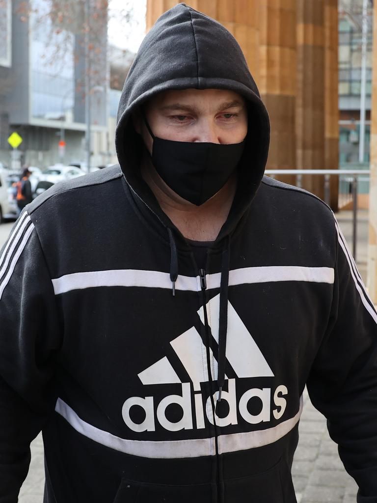 Man wearing a black adidas hoodie and mask.