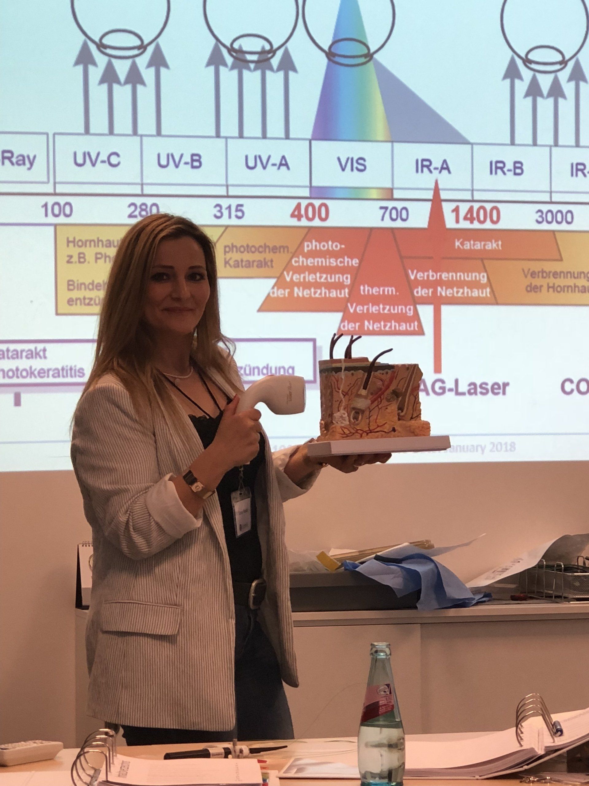 Eine Frau hält ein Stück Kuchen vor einer Projektionsleinwand.