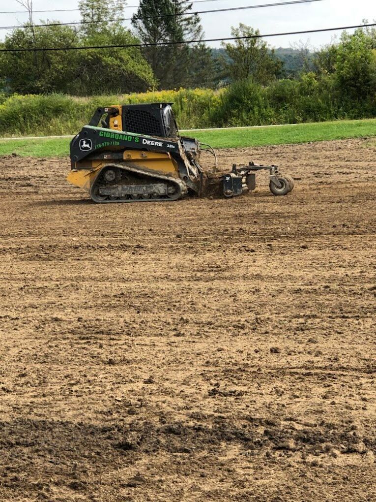 A bulldozer is working on a dirt field.