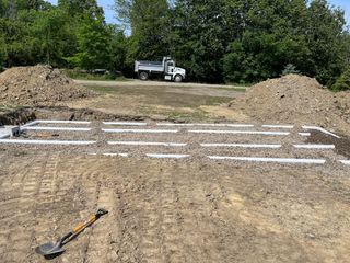 A large pile of dirt is sitting in front of a house.