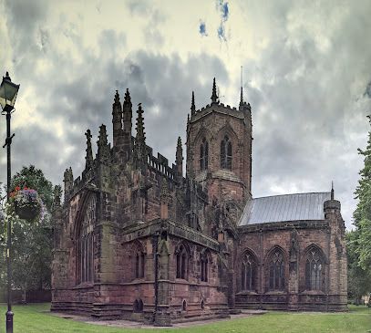 Historic Gothic church with ornate stone towers and arched windows under a cloudy sky