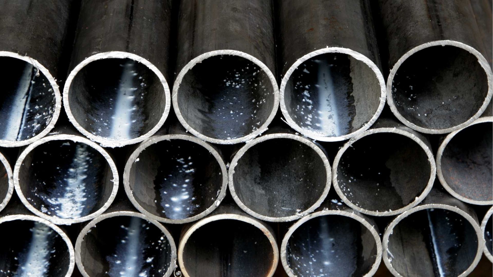 A bunch of metal pipes are stacked on top of each other.