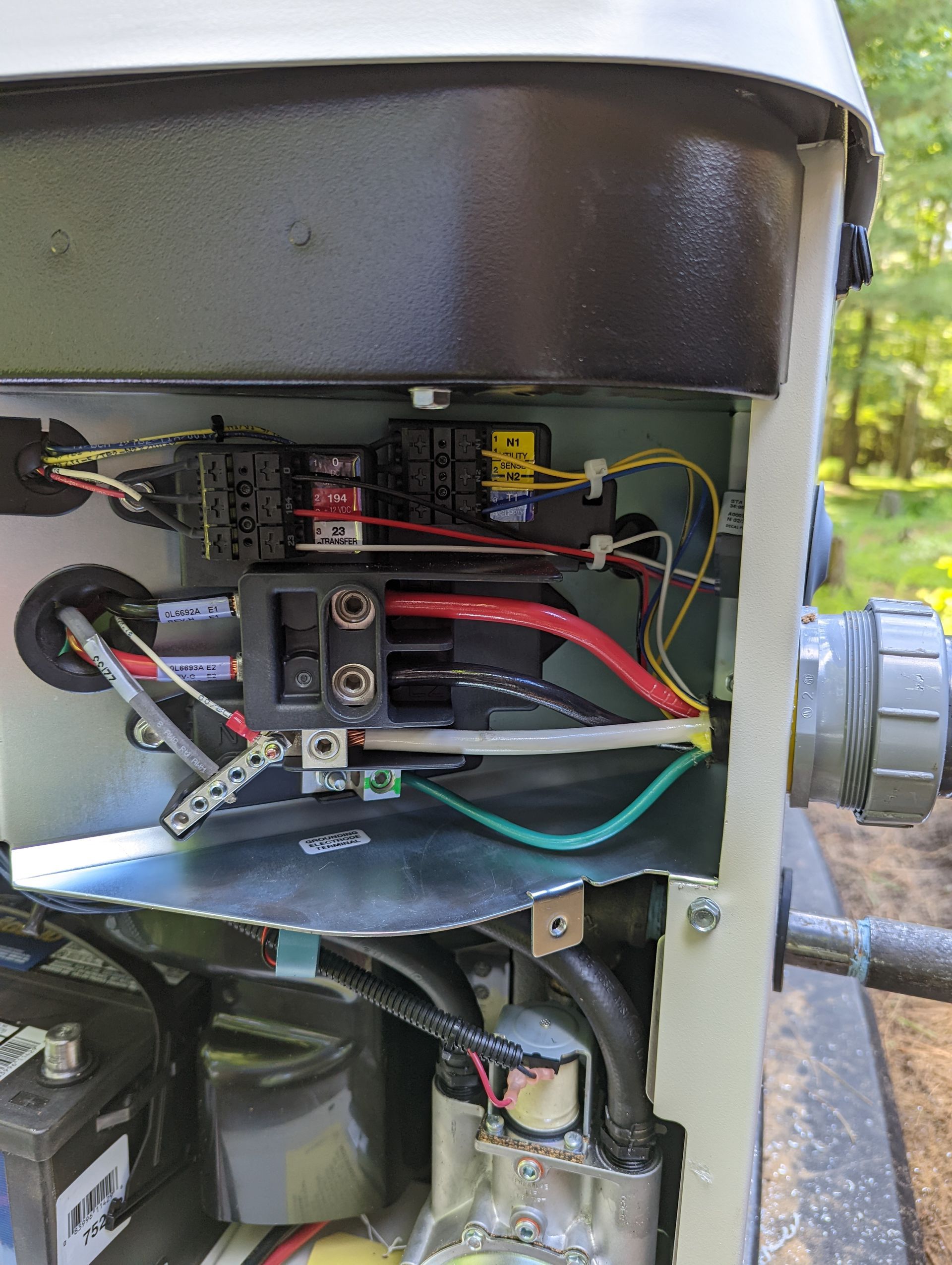 The inside of a generator with a lot of wires coming out of it.