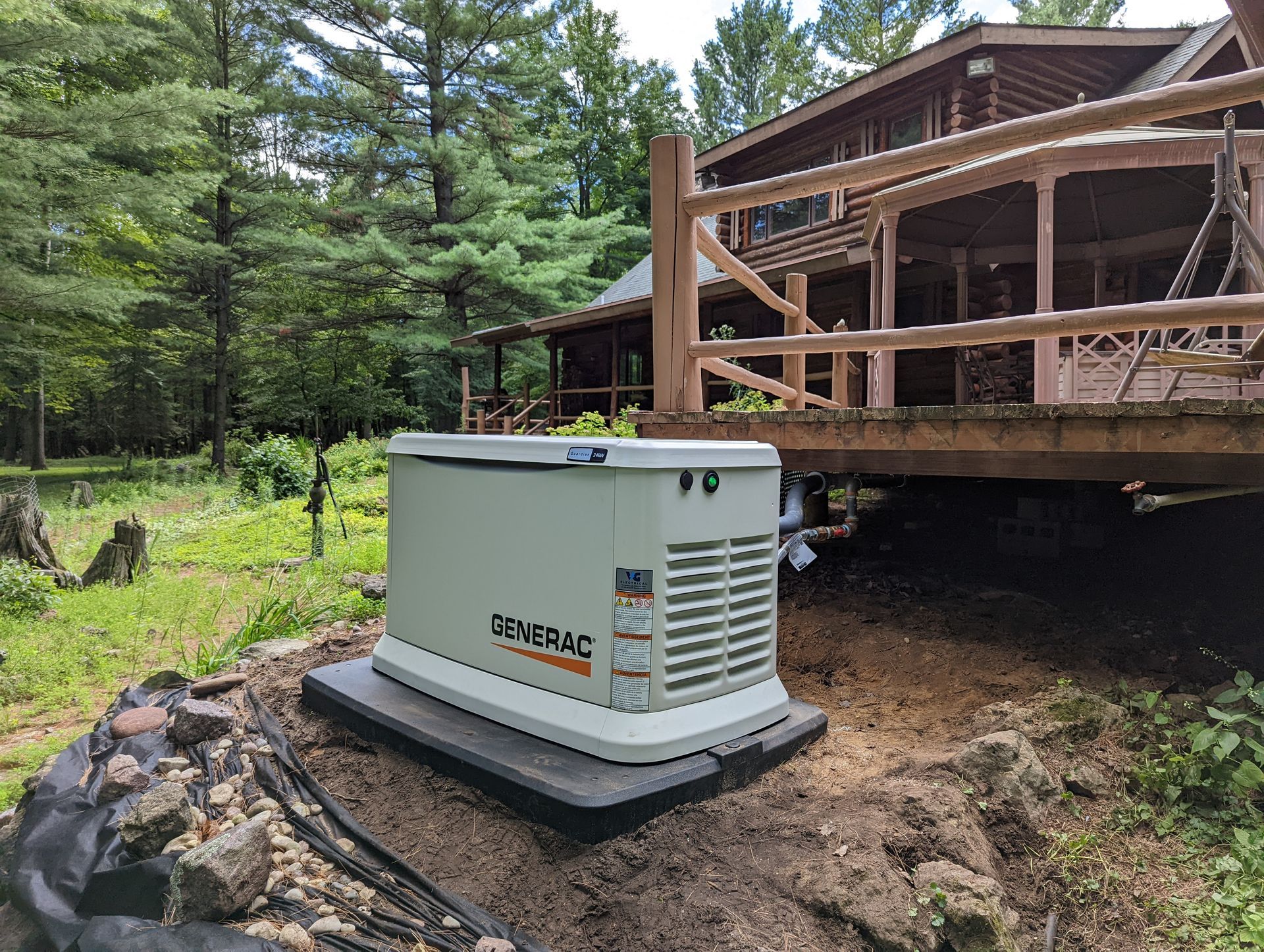 A generator is sitting in the dirt in front of a house.