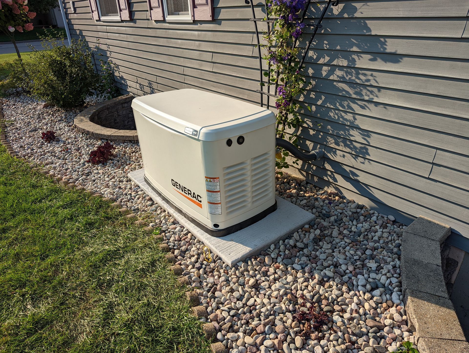A generator is sitting on the side of a house.