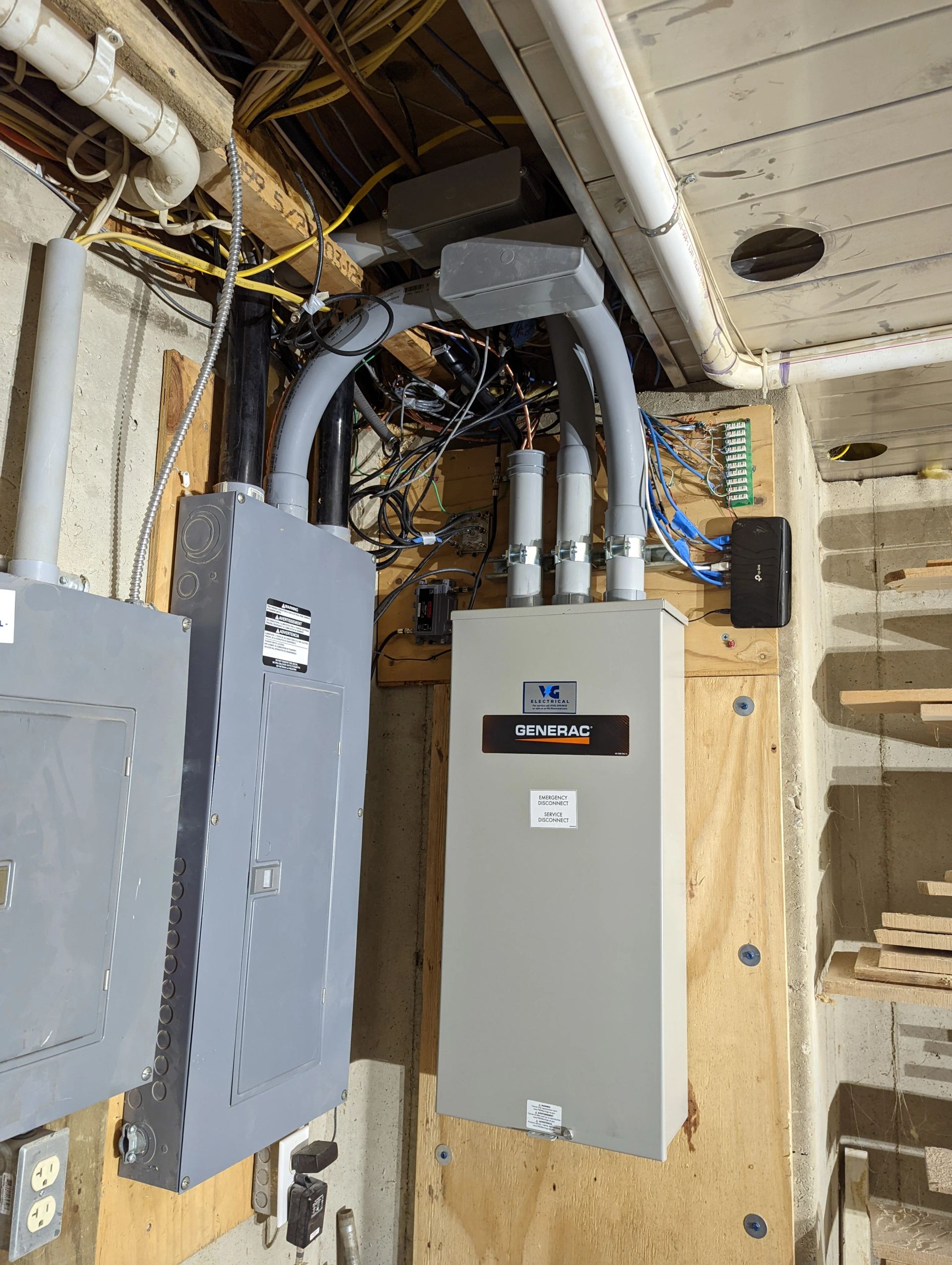 A gray electrical box is hanging on a wooden wall.