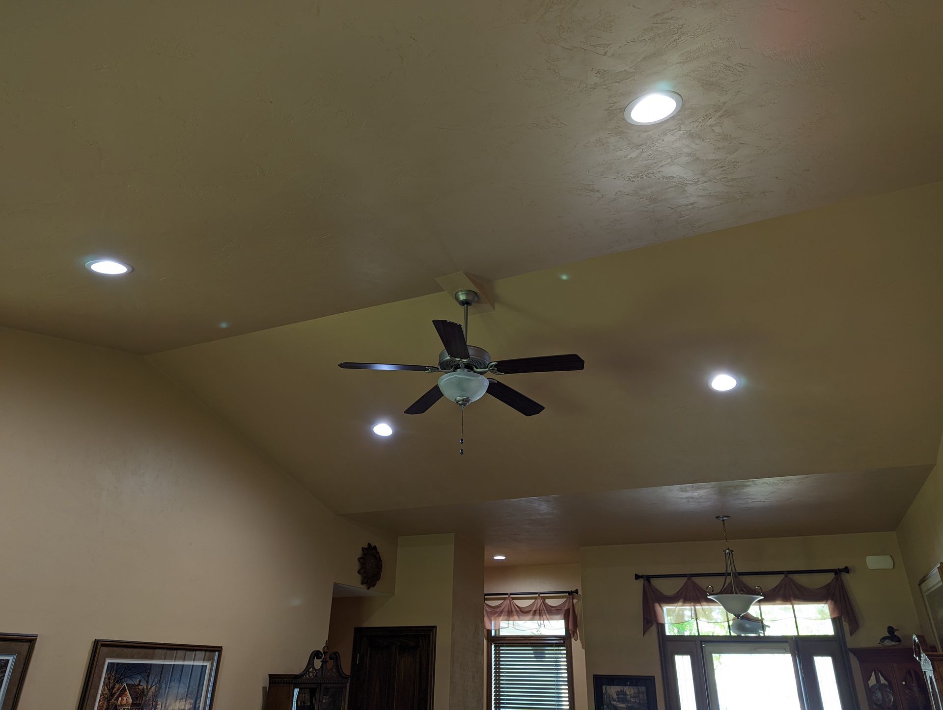 A ceiling fan is hanging from the ceiling of a living room.