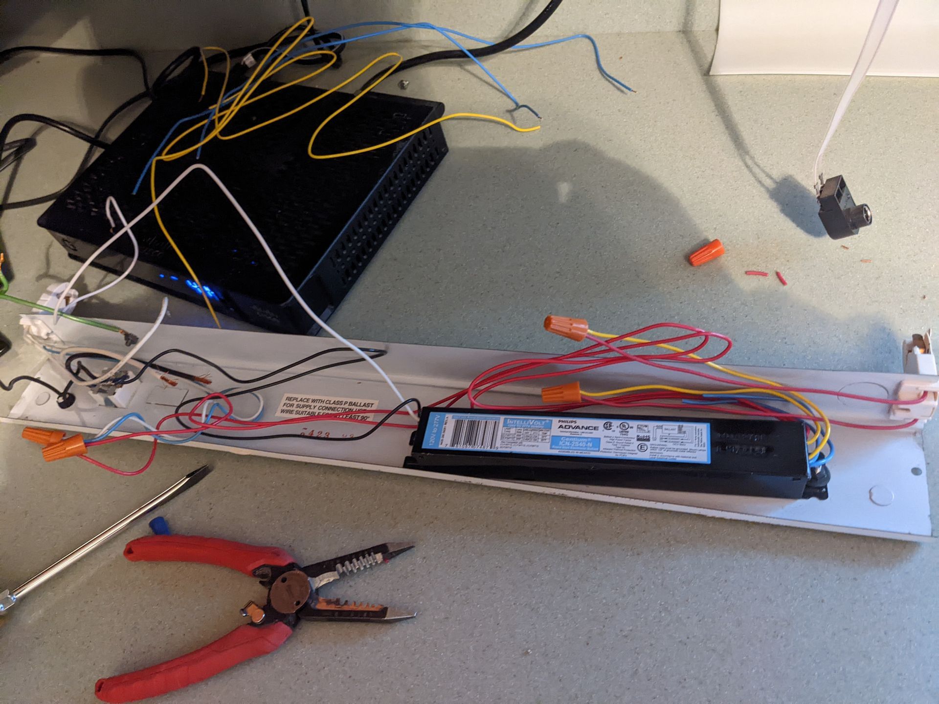 A bunch of wires are laying on a table with a pair of pliers