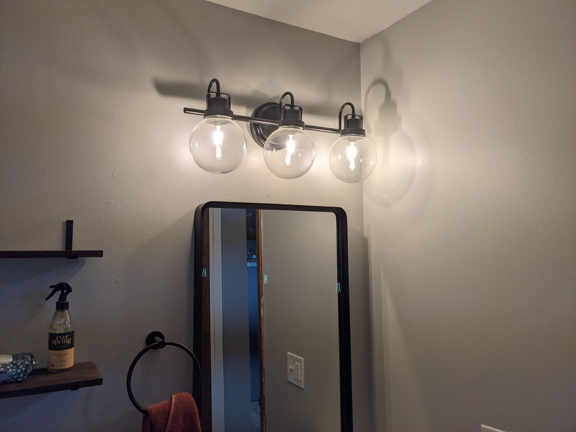 A bathroom with a vanity light and a mirror.