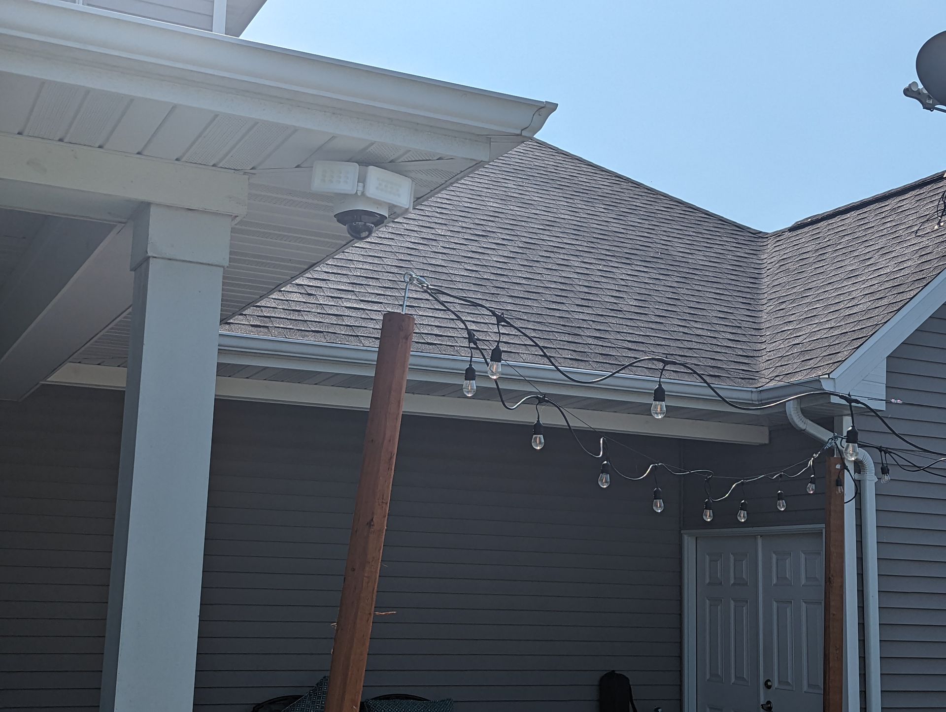 A house with a porch and a roof with lights on it.