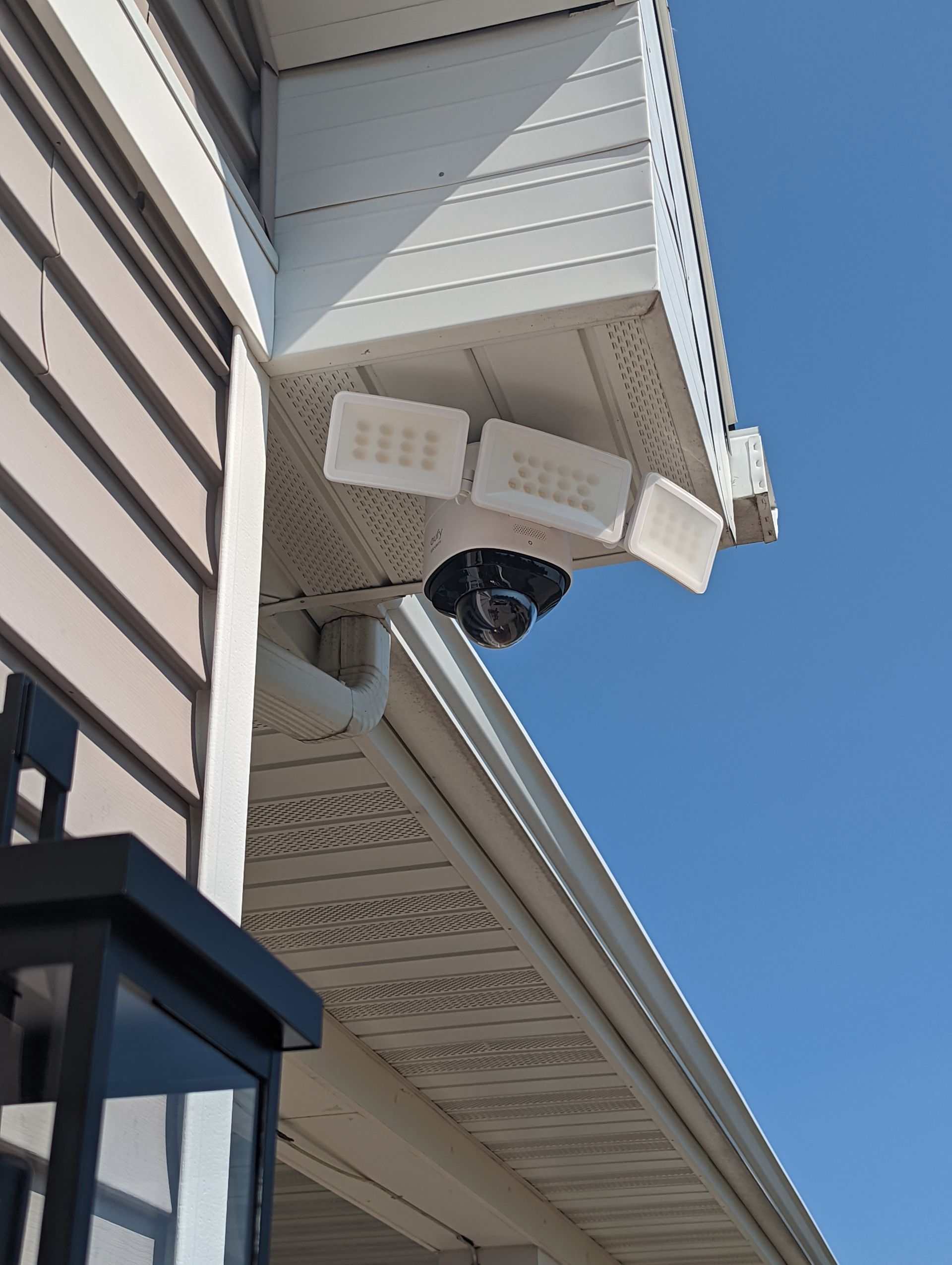 A security camera is mounted on the side of a house