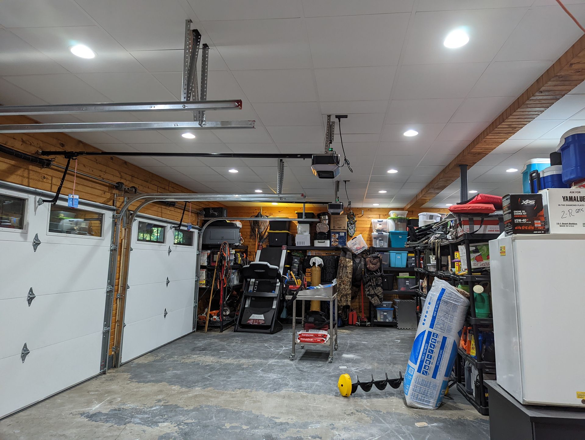 A garage with two garage doors and a ceiling fan.