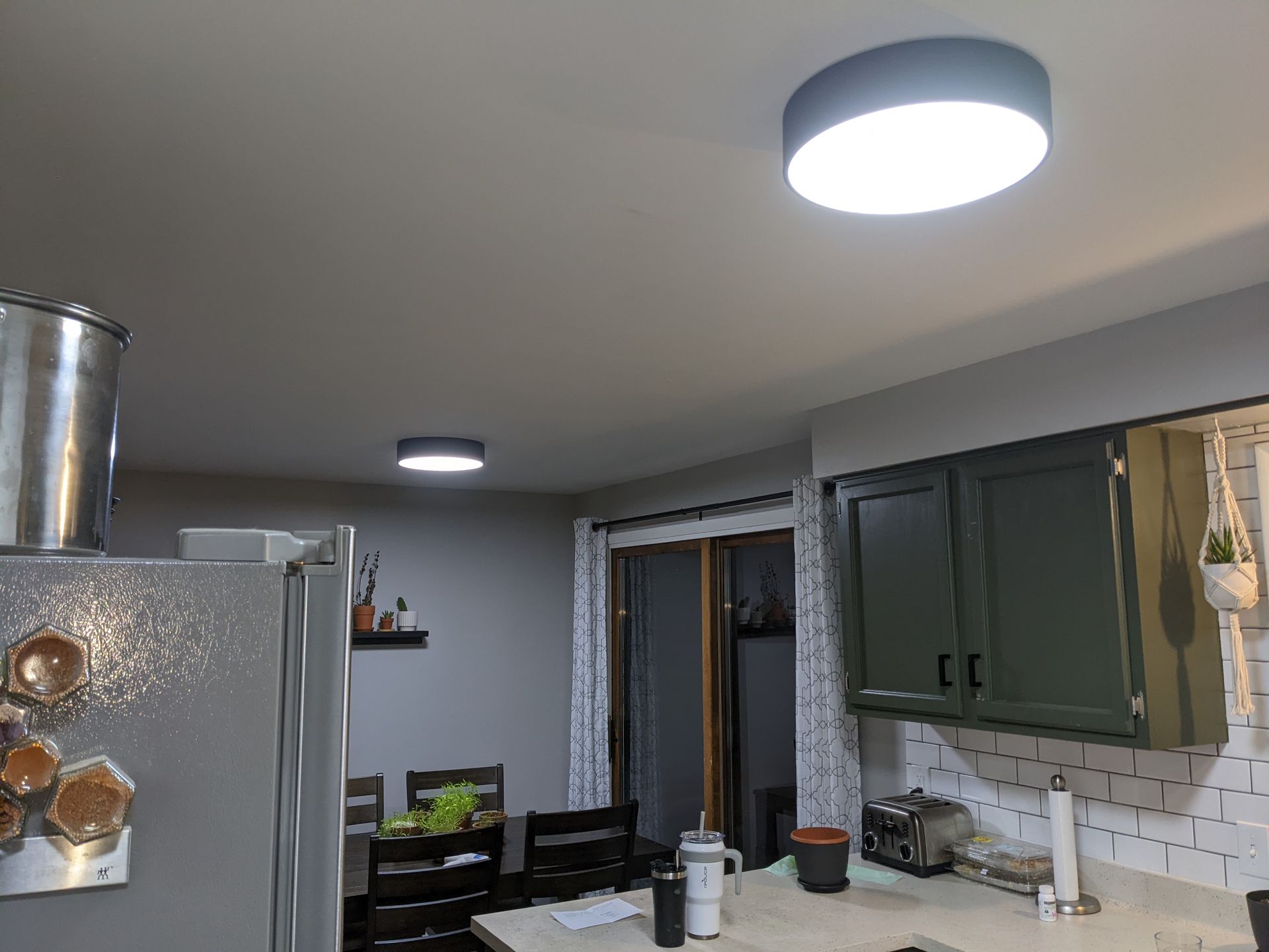 A kitchen with green cabinets and a ceiling light.