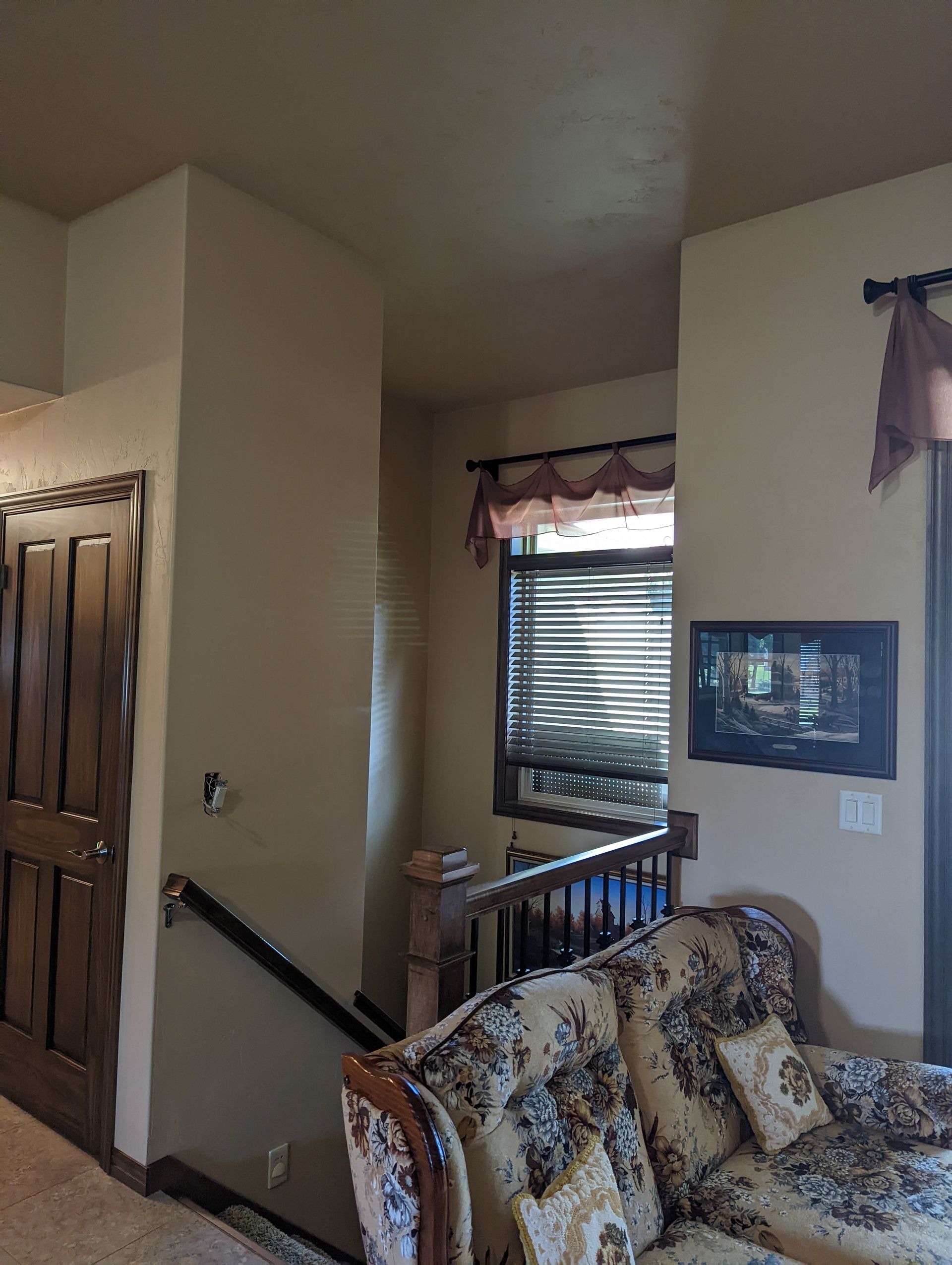 A living room with a couch , chair , and stairs.