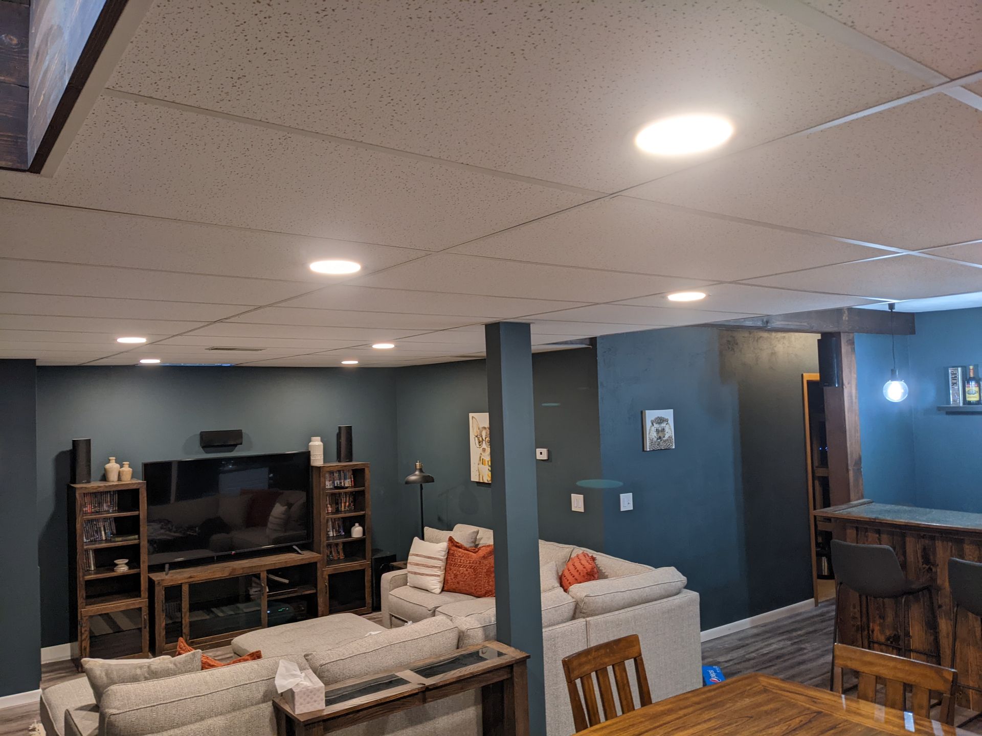 A living room with a couch , television , table and chairs.