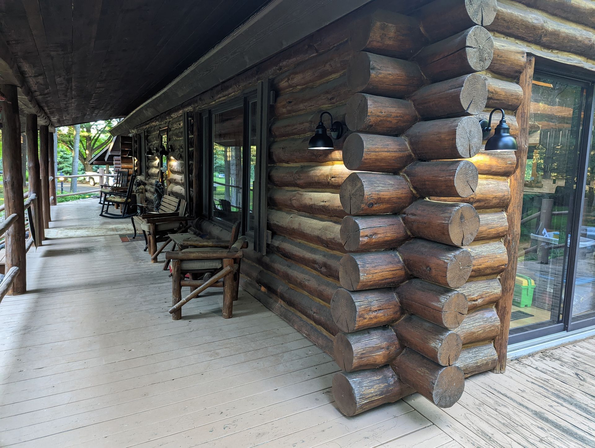 A log cabin with a porch and chairs on it.