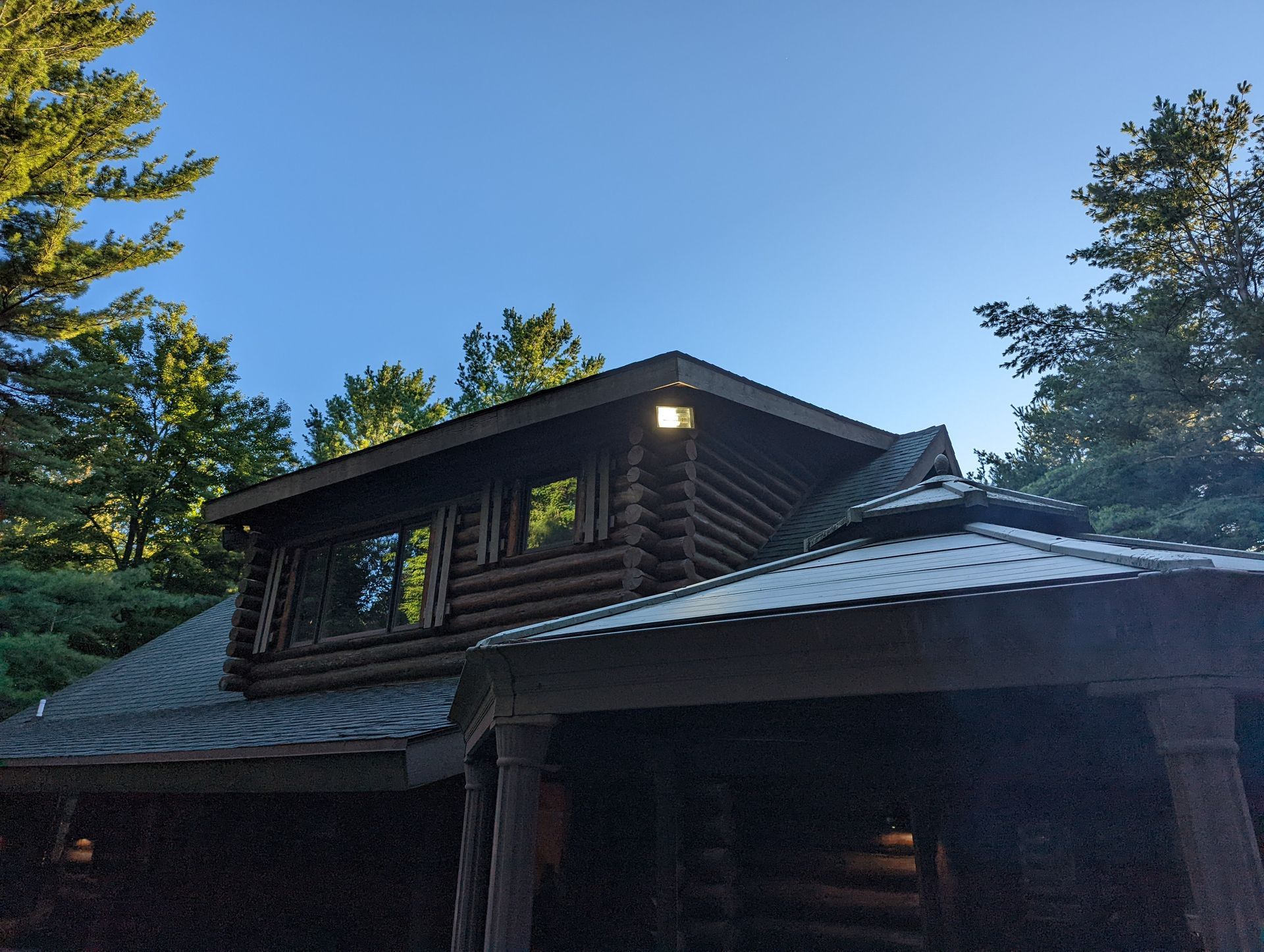 A log cabin with a metal roof is lit up at night