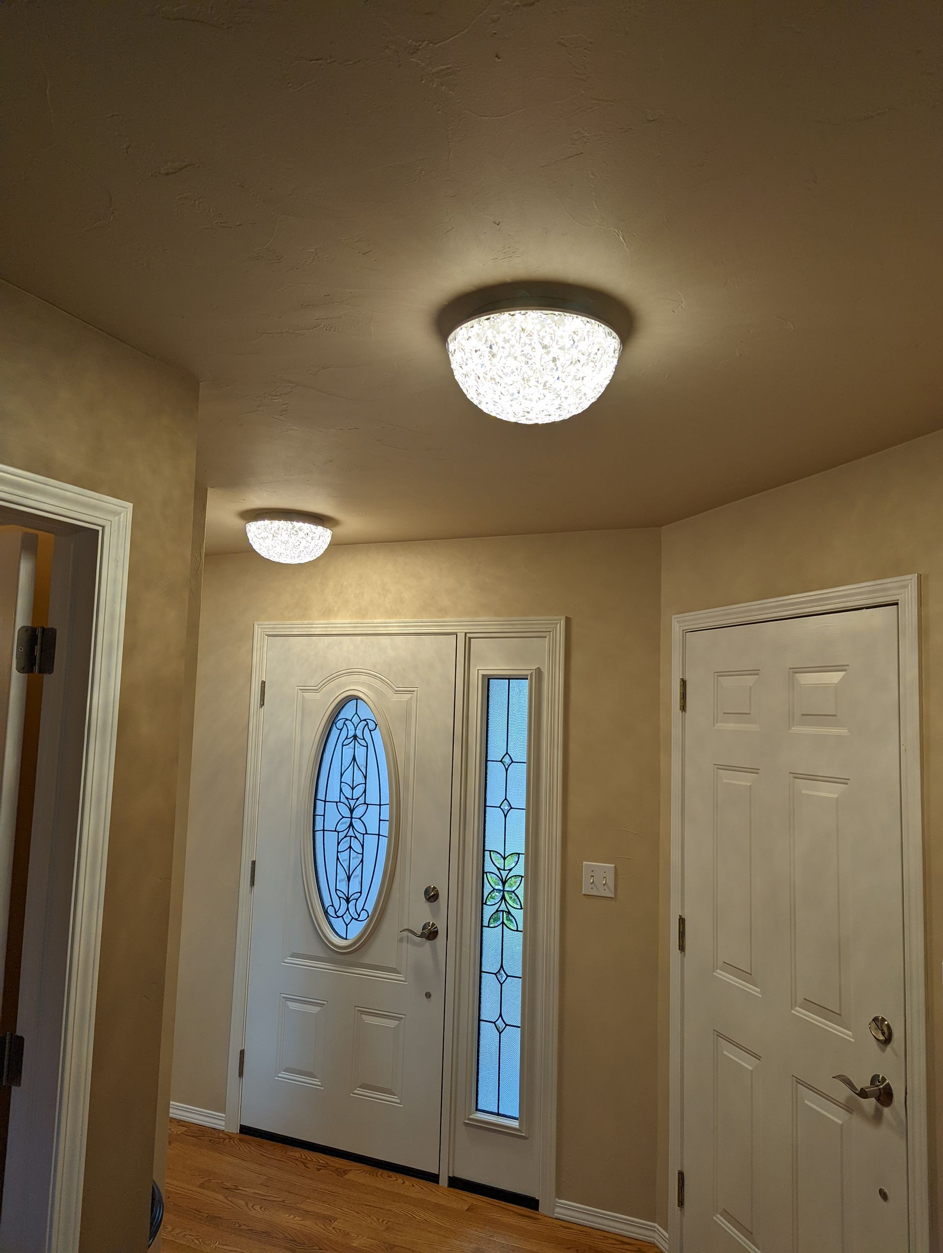 A hallway with a door and a light on the ceiling.