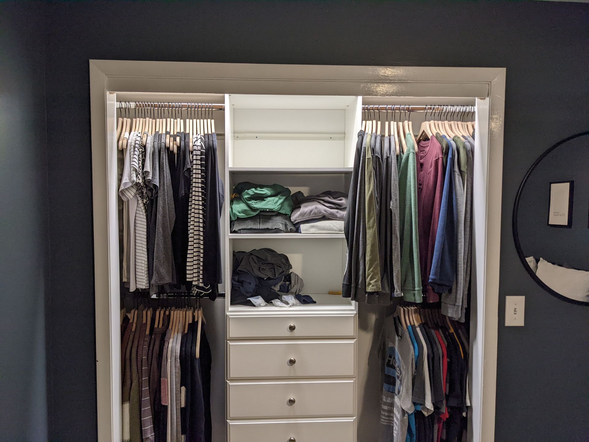 A closet filled with lots of clothes and a mirror.