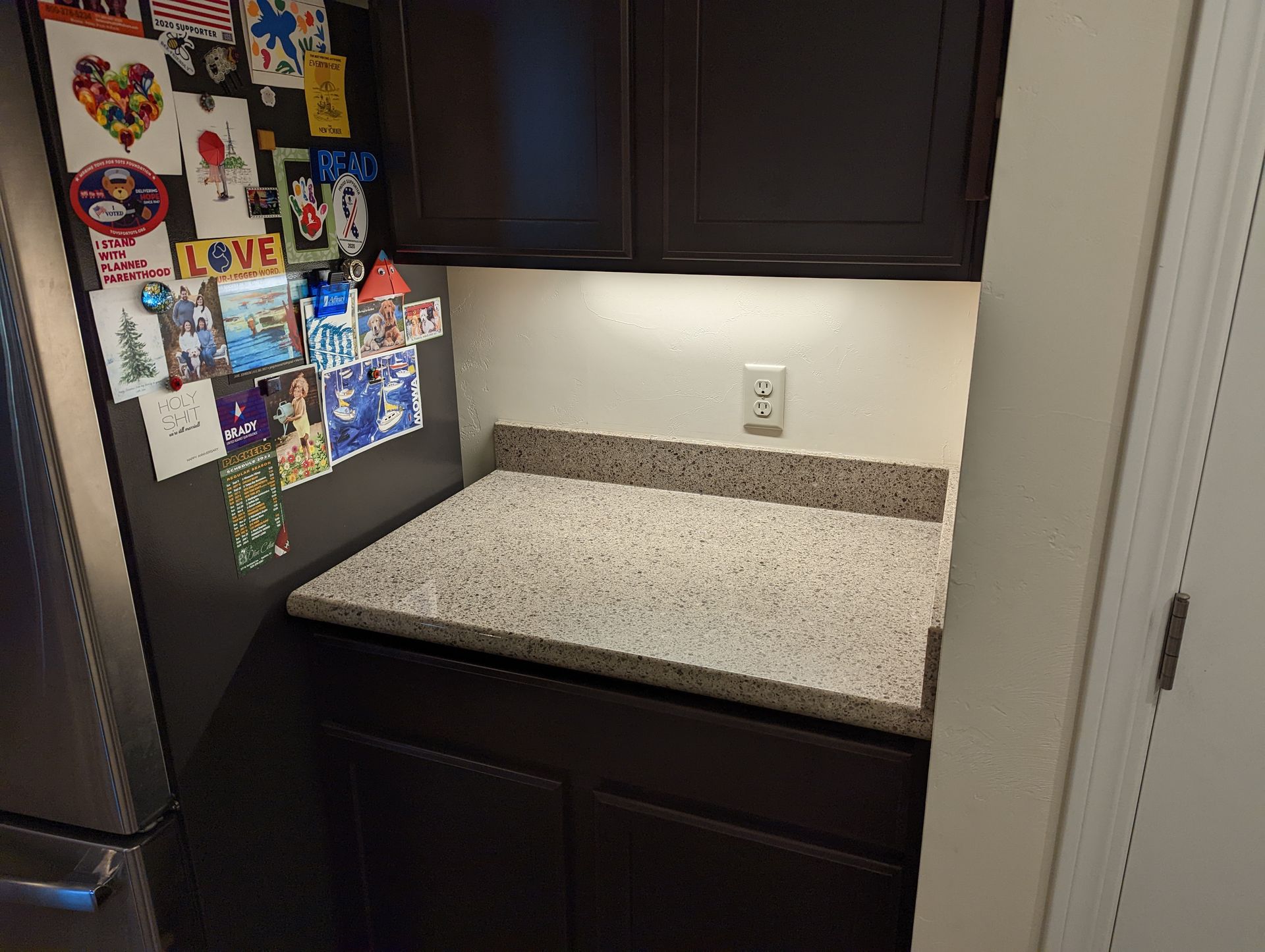 A kitchen with a granite counter top and a refrigerator.