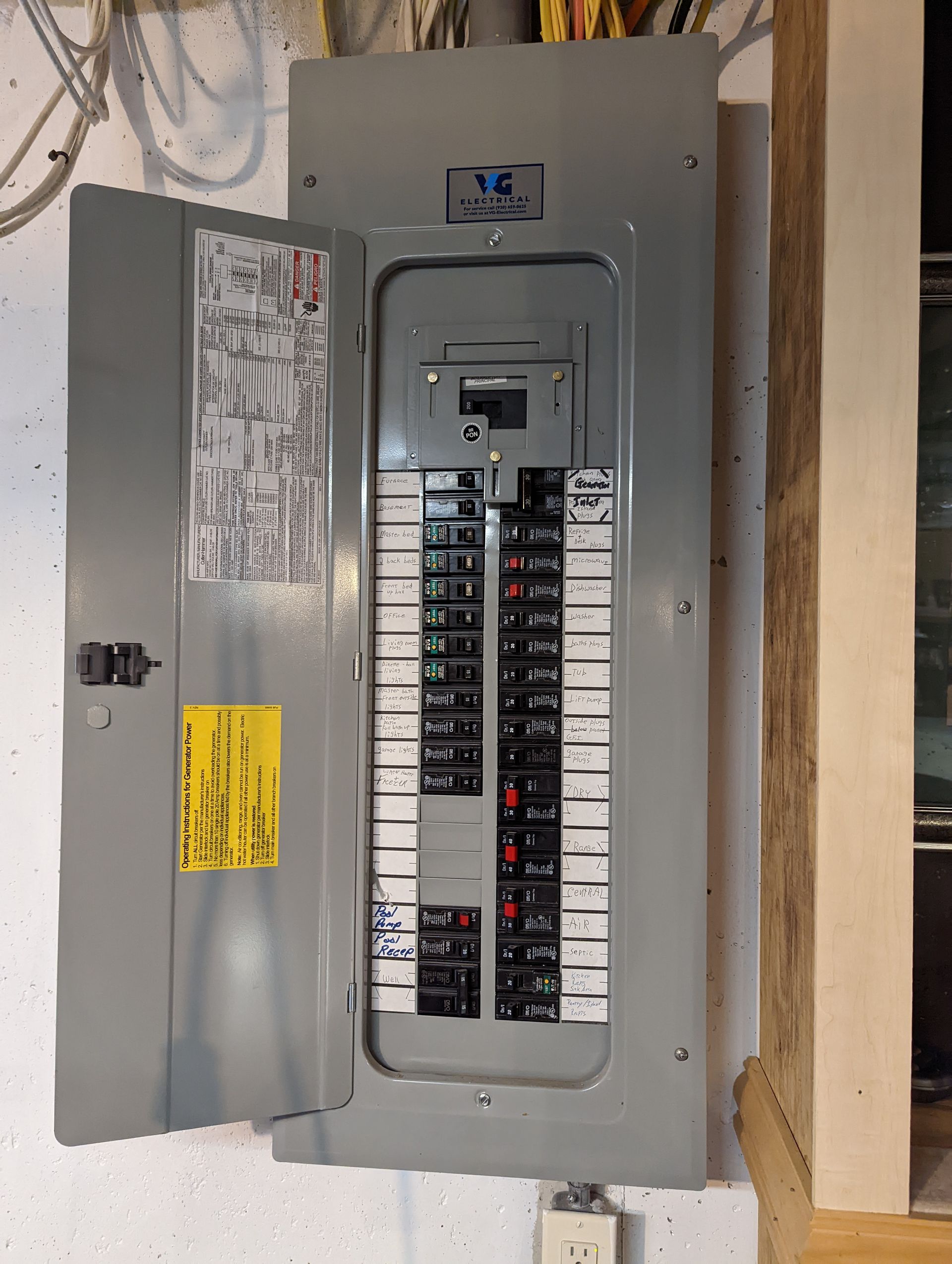 An open electrical box with a yellow sticker on it that says 