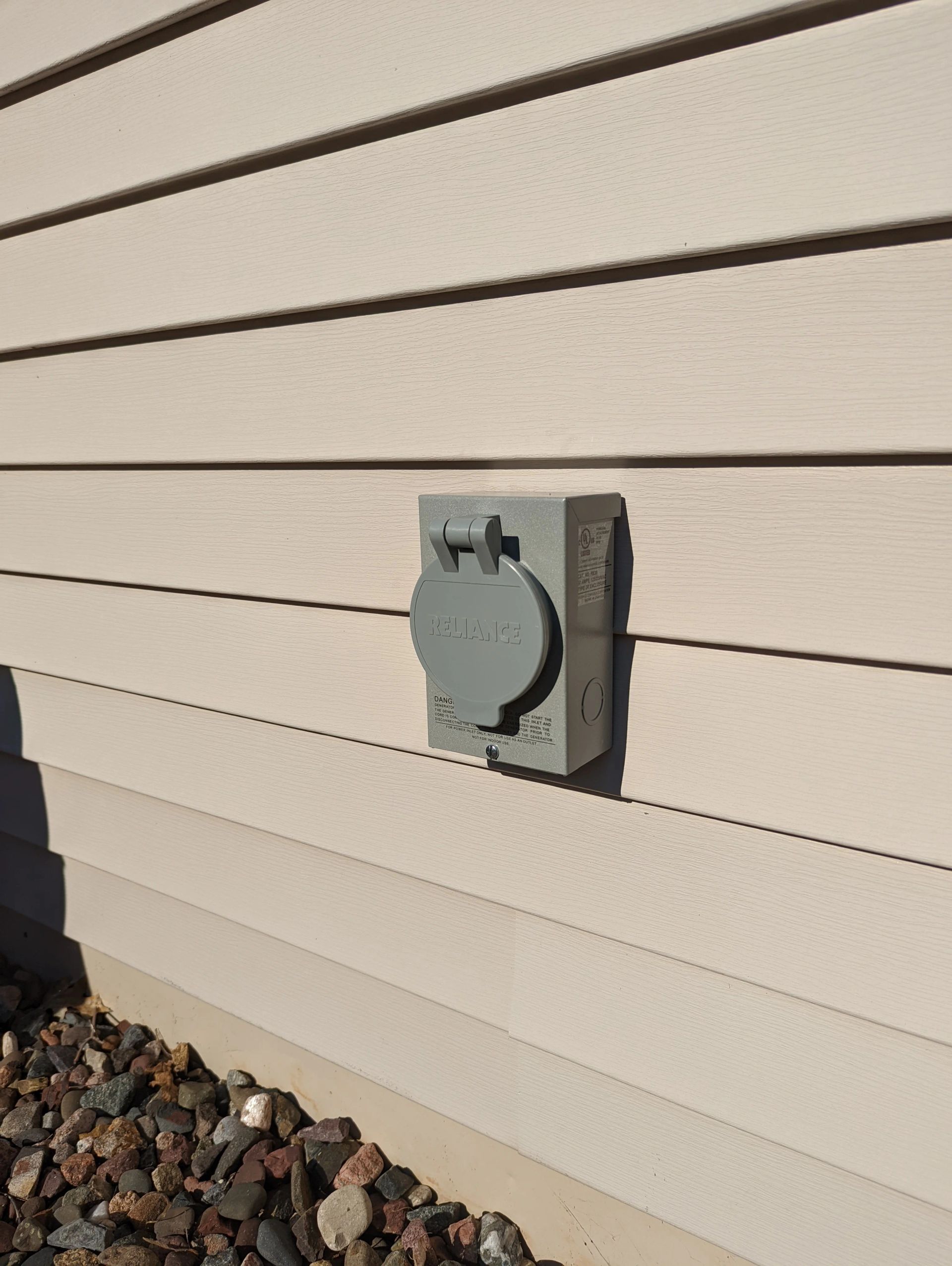 A close up of a electrical outlet on the side of a house.