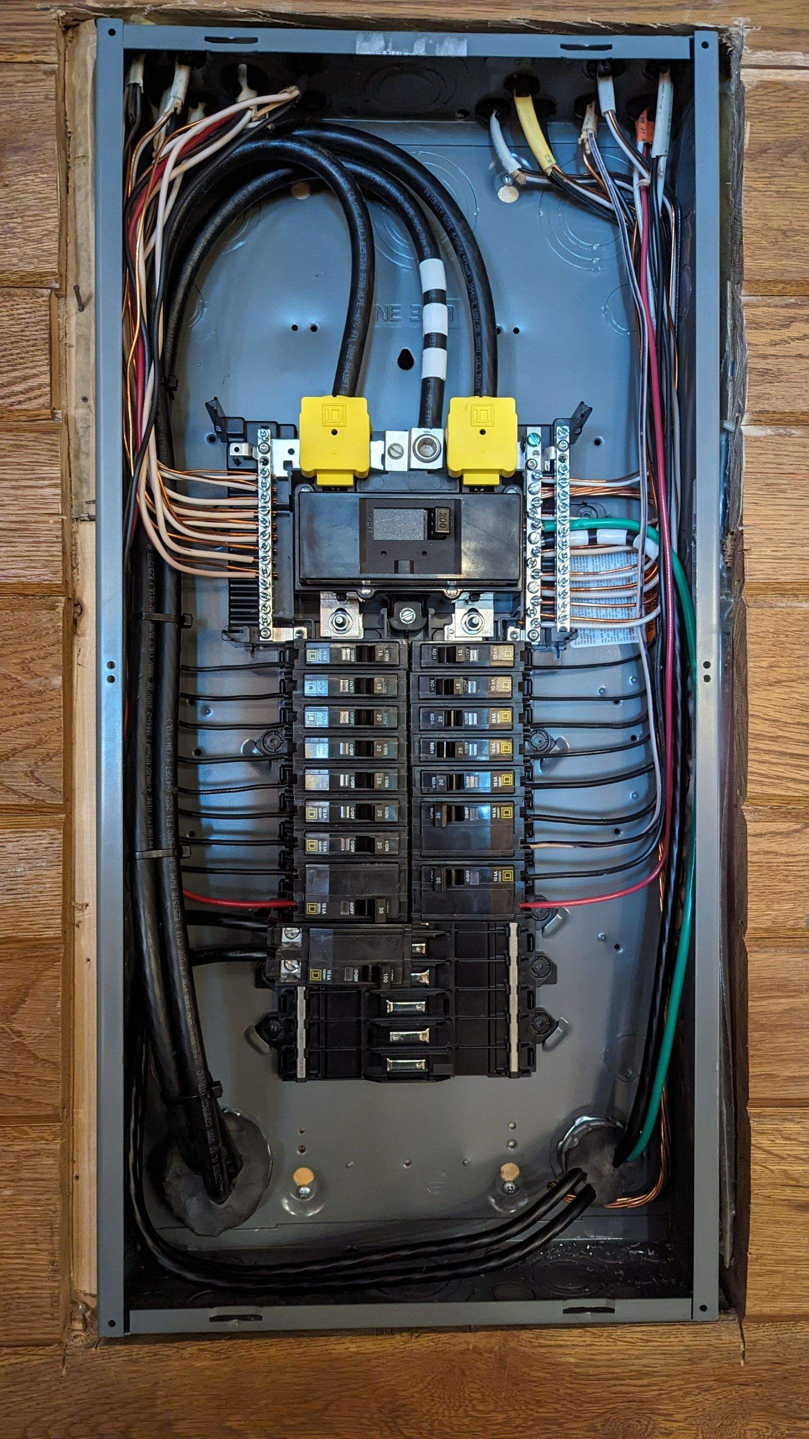 A close up of an electrical panel on a wooden wall.