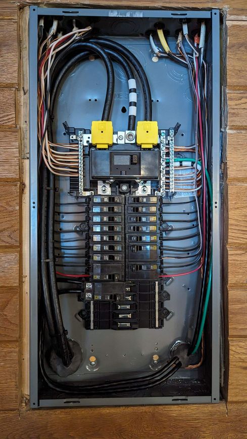 A close up of an electrical panel on a wooden wall.