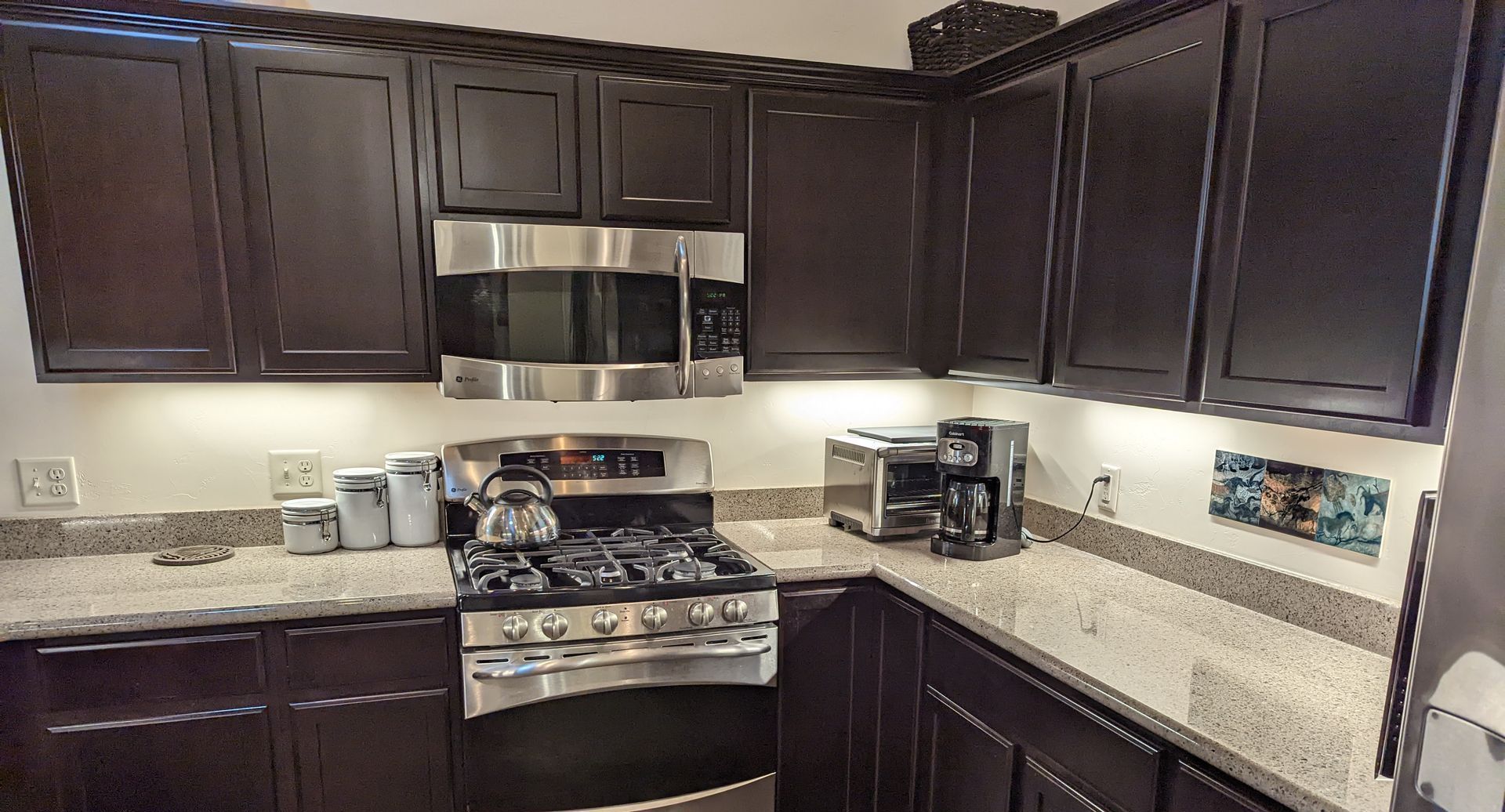 A kitchen with dark cabinets and stainless steel appliances