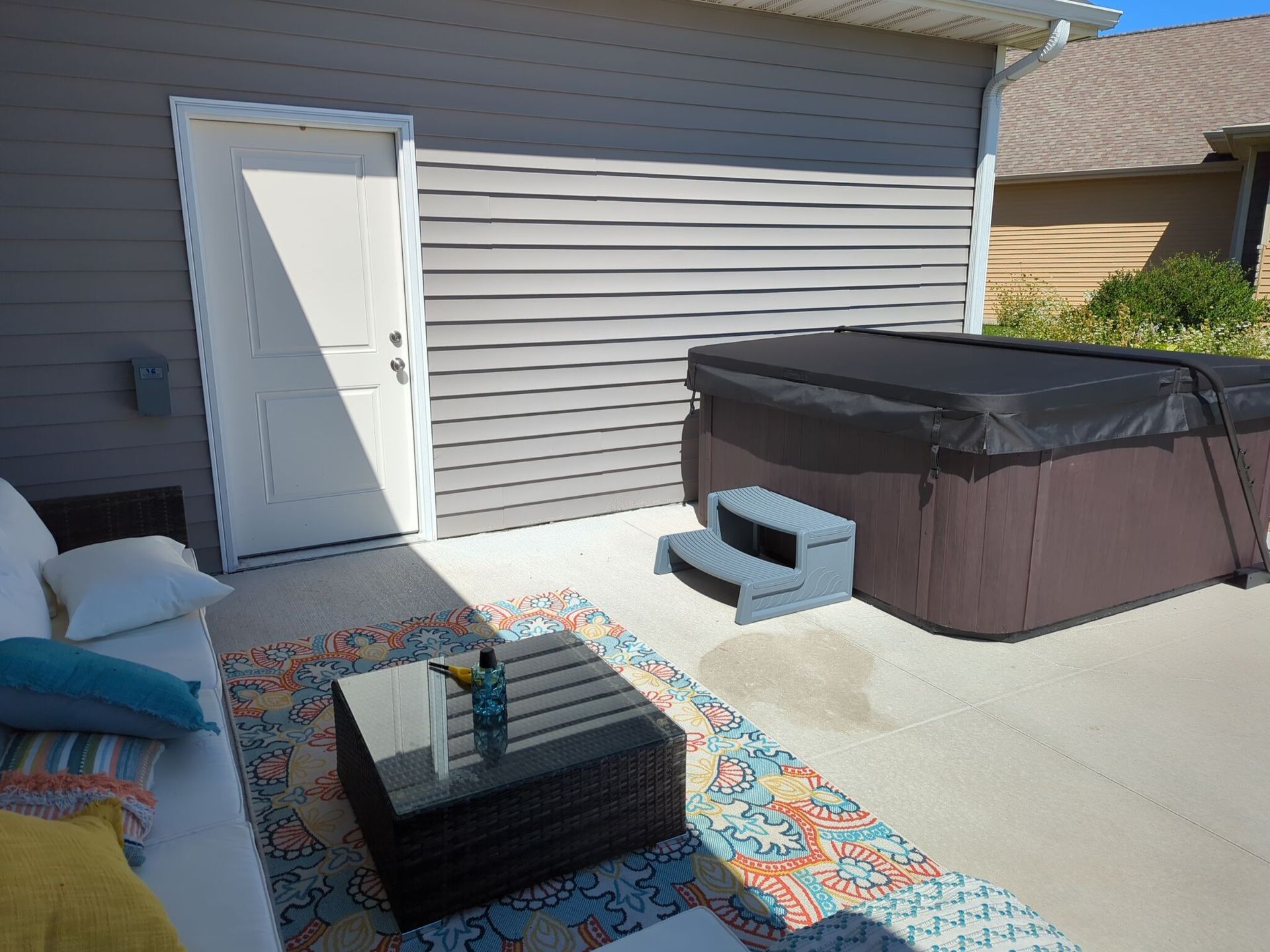 There is a hot tub in the backyard of a house.