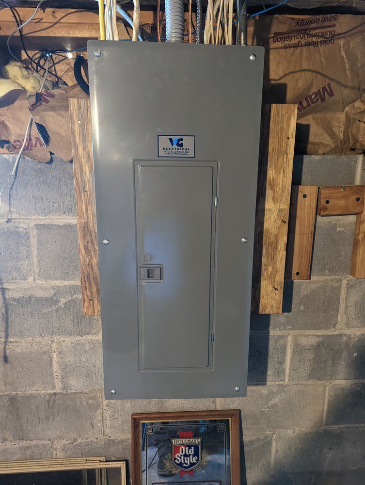 A gray electrical box is hanging on a brick wall.