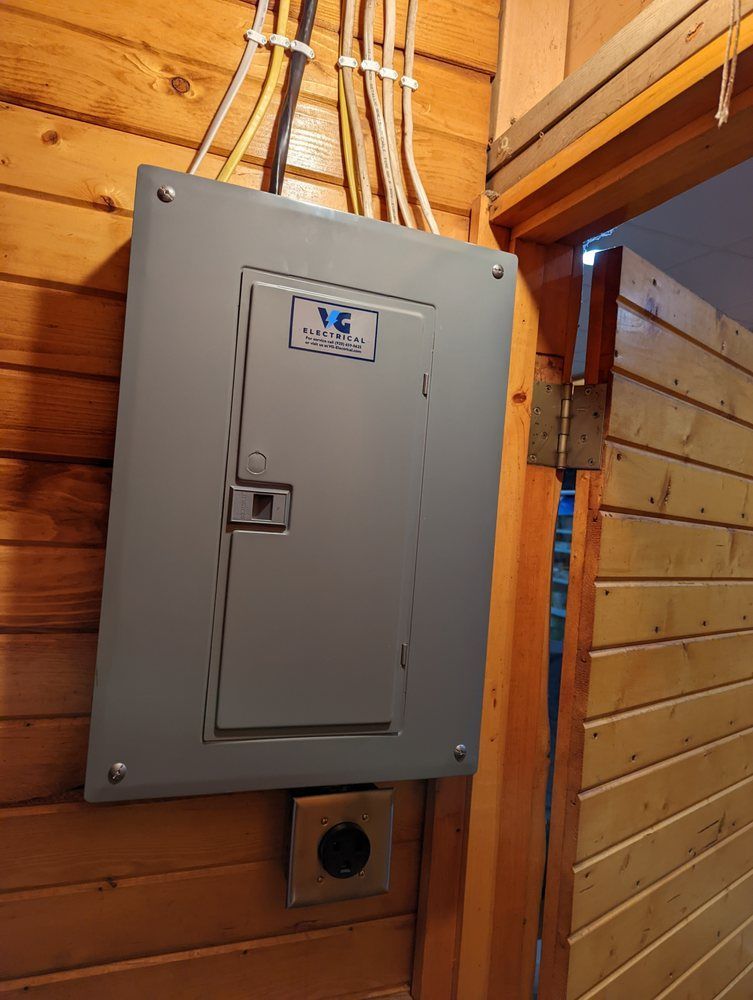 A electrical box is hanging on a wooden wall next to a door.