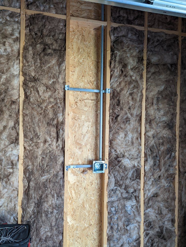 A wall with insulation and a box on it.