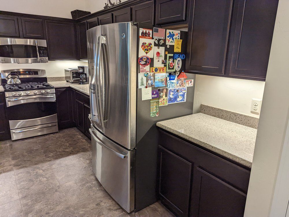 A kitchen with a stainless steel refrigerator and a stove.