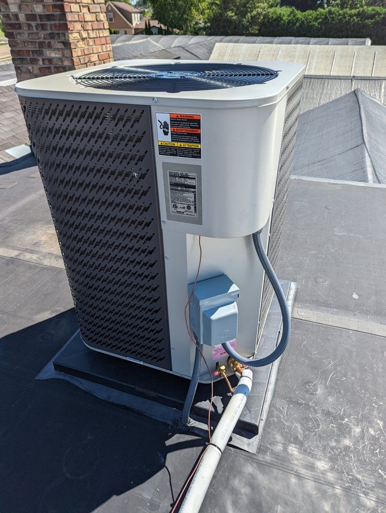 A large air conditioner is sitting on top of a roof.