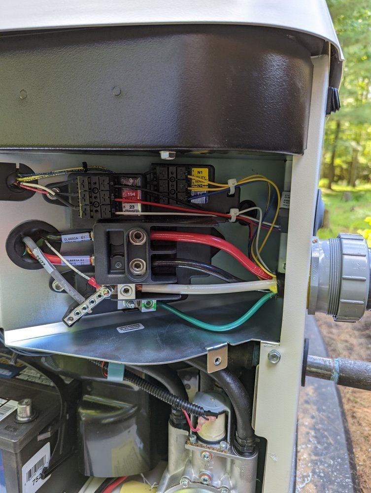 The inside of a generator with a lot of wires coming out of it.