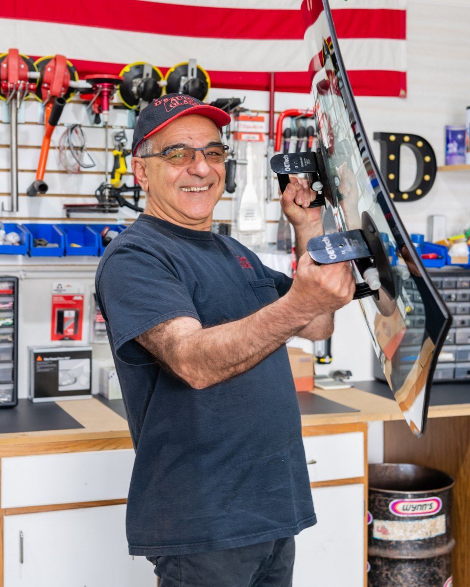 A man is holding a skateboard in a garage