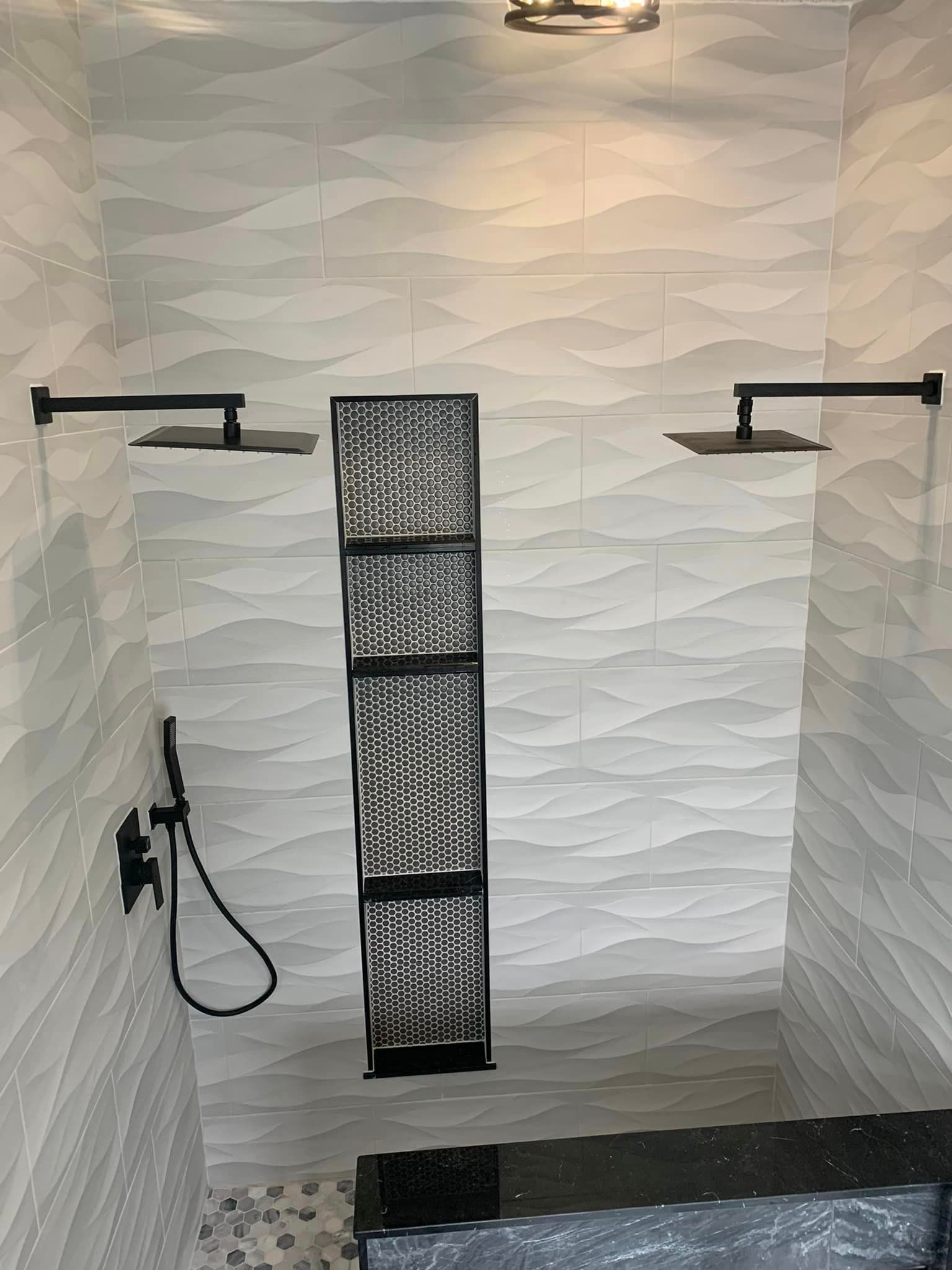 A bathroom with two shower heads and a black shower head.
