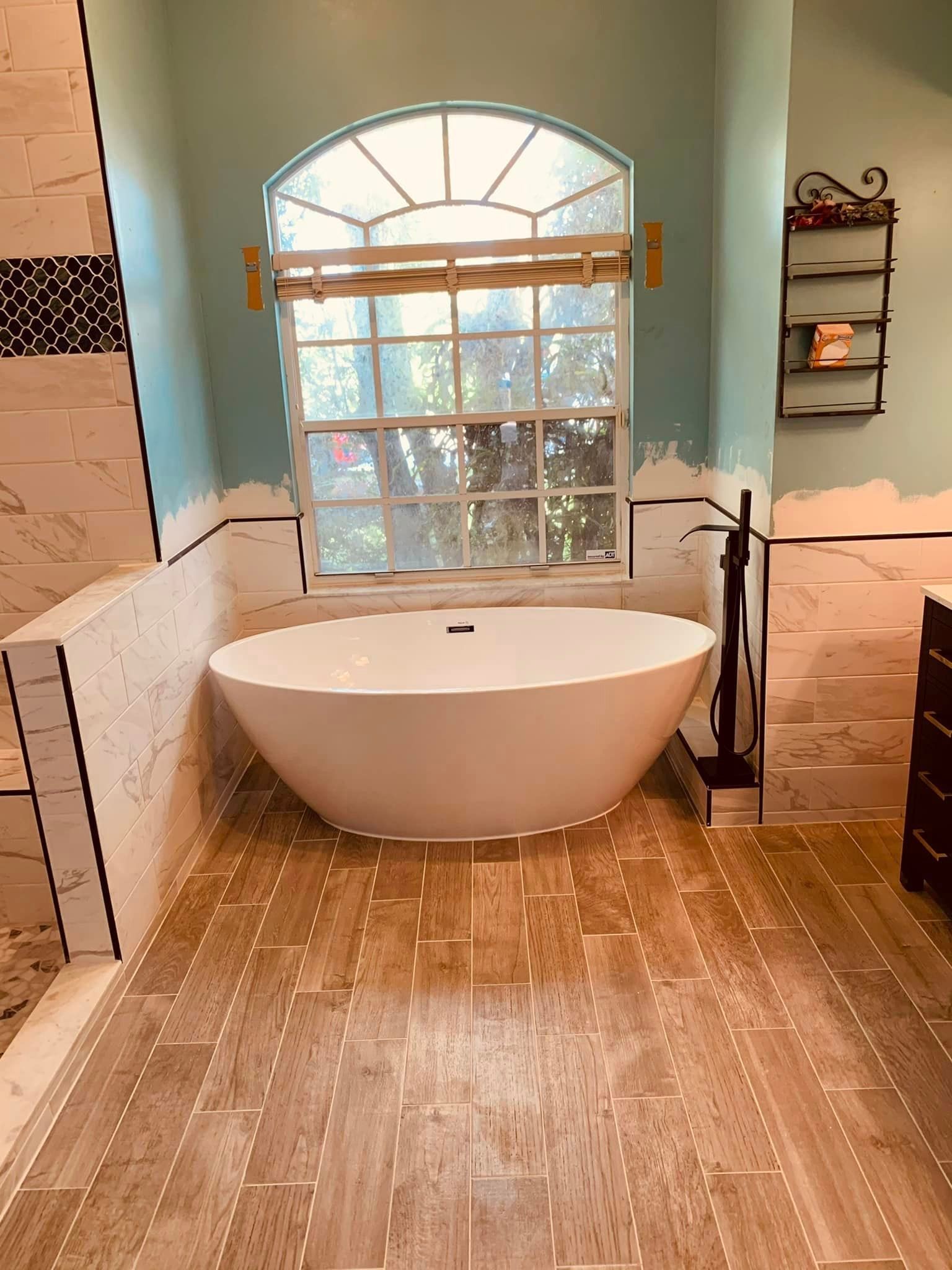 A bathtub is sitting in a bathroom next to a window.