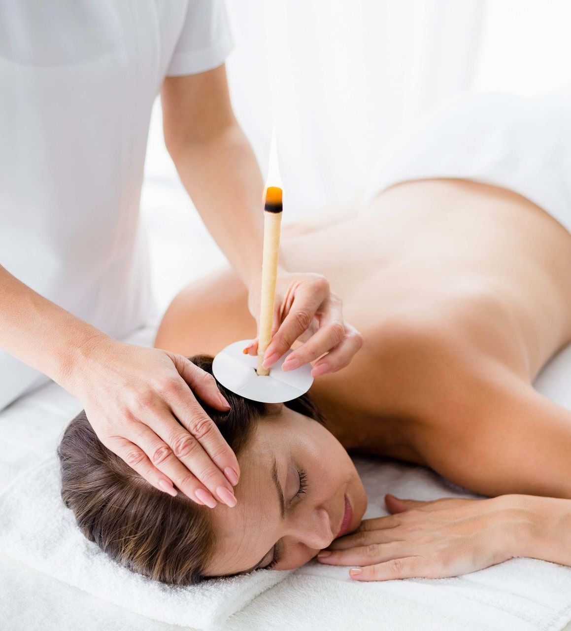 Girl getting ear candle therapy