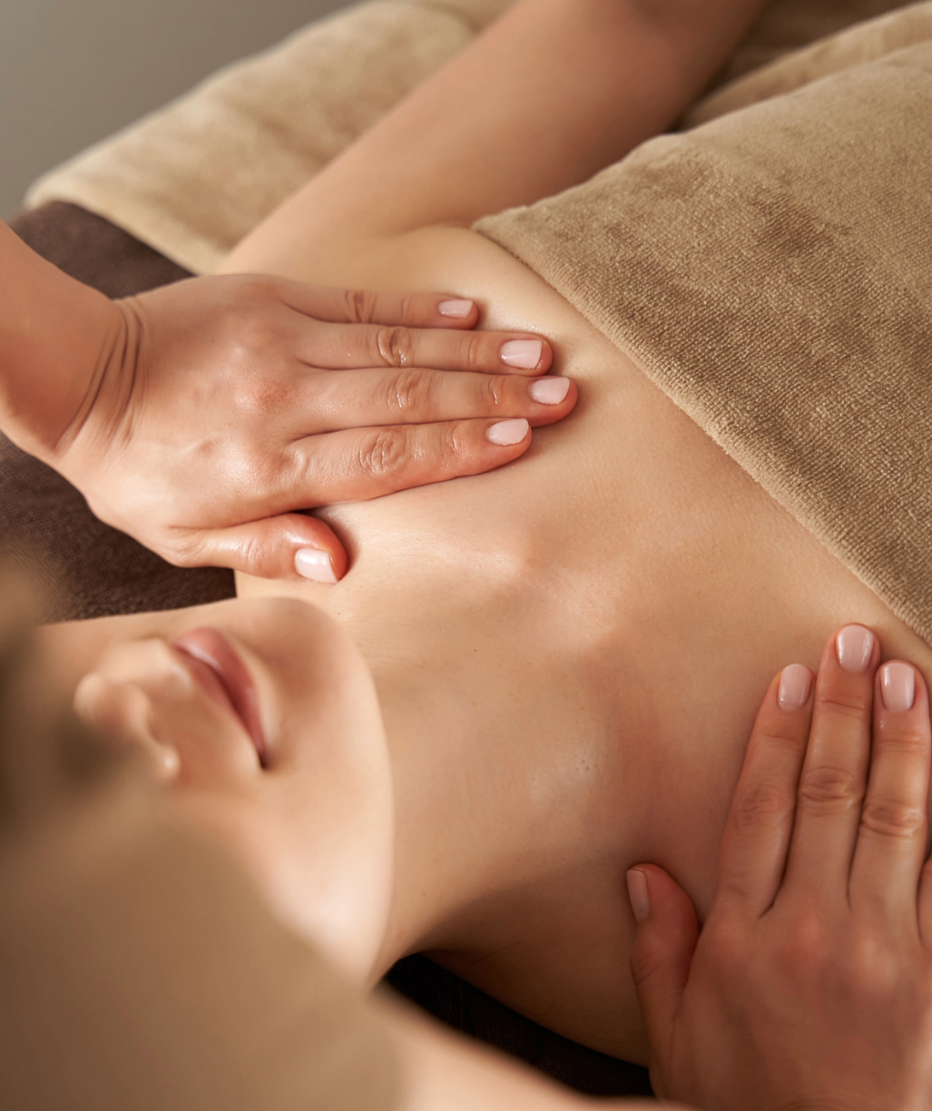 a woman is getting a hot stone therapy with rocks on her back