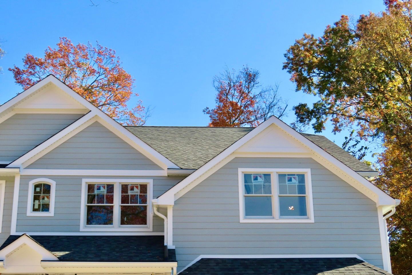 A house with a blue sky and trees in the background