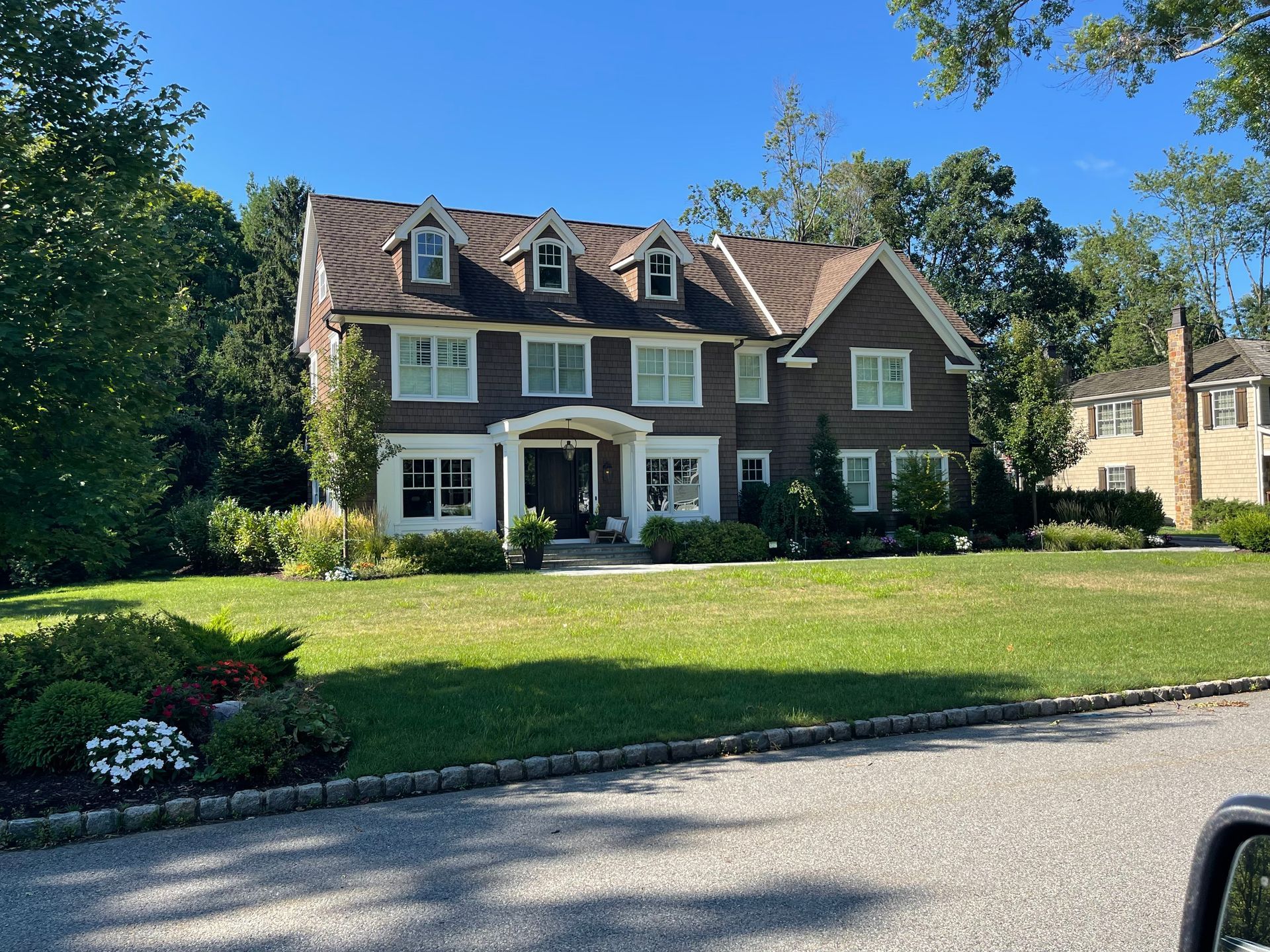 A large brick house with a large lawn in front of it