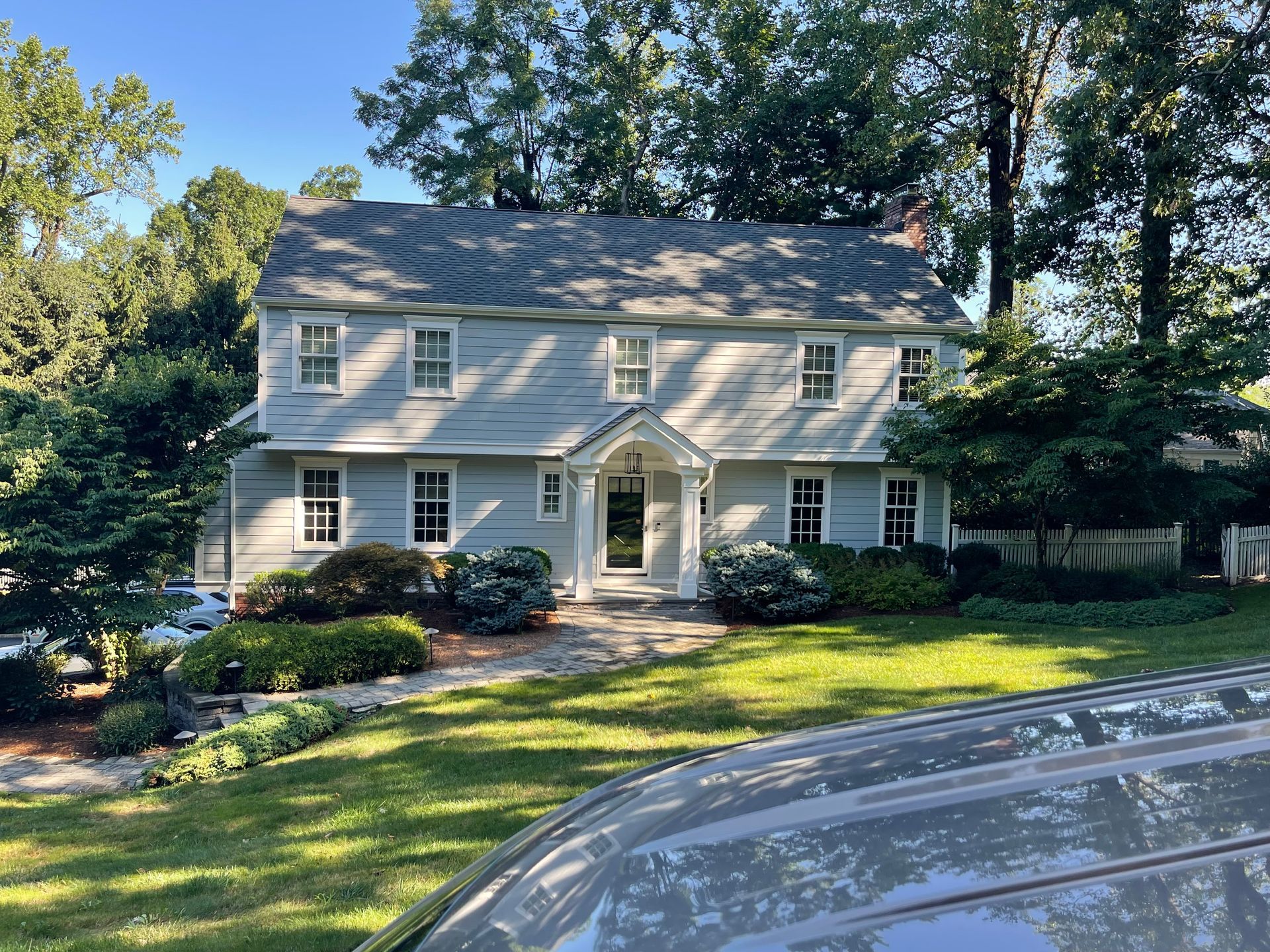 A white house with a car parked in front of it.