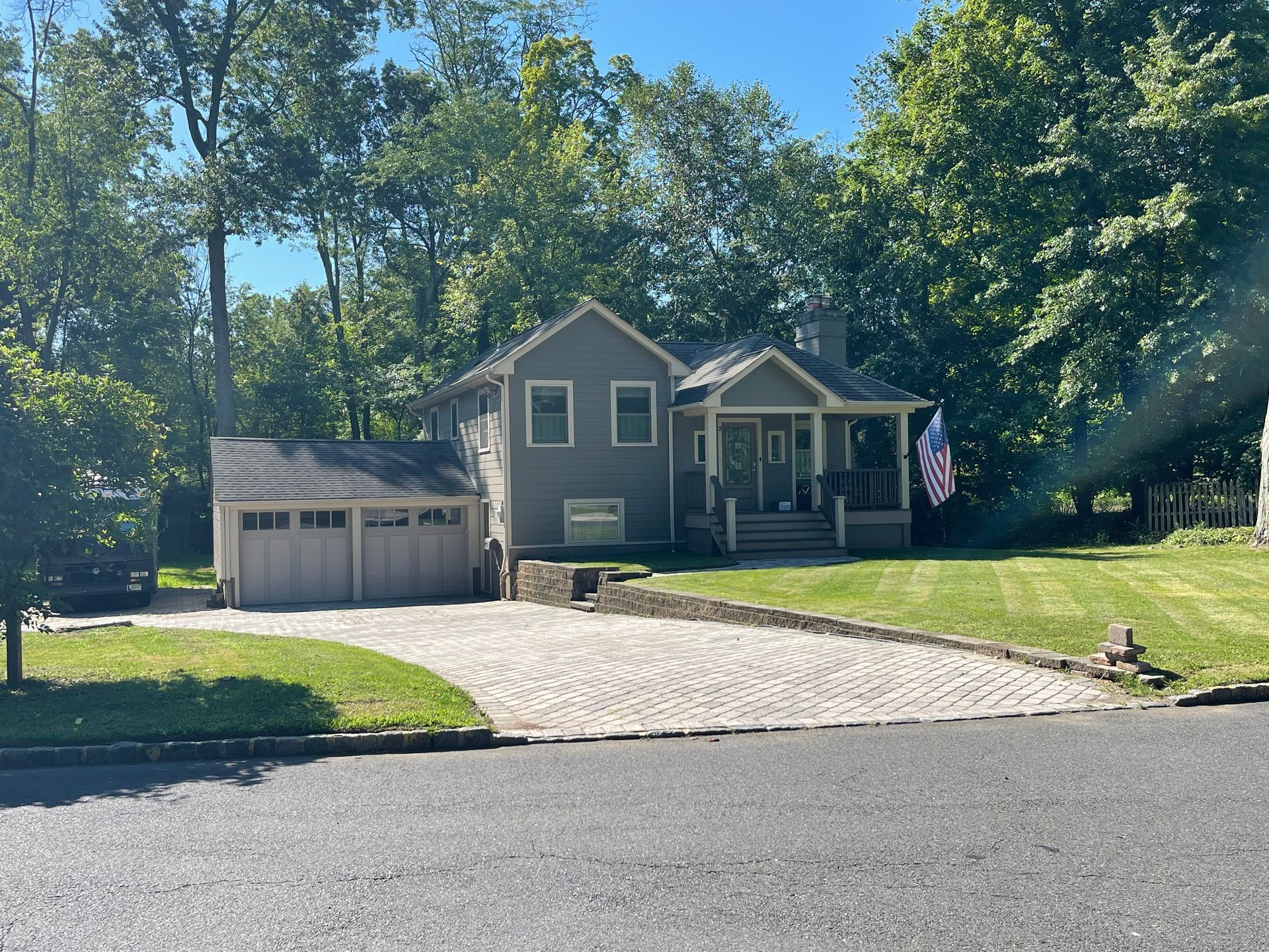 A house with a garage and a flag in front of it