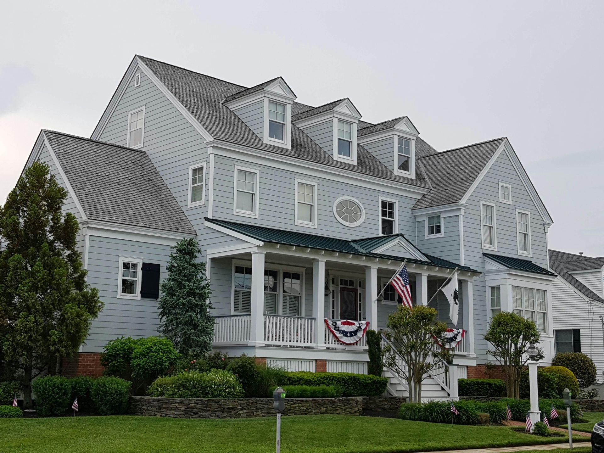 Roofer repairing damaged shingles on a residential roof in a suburban neighborhood.