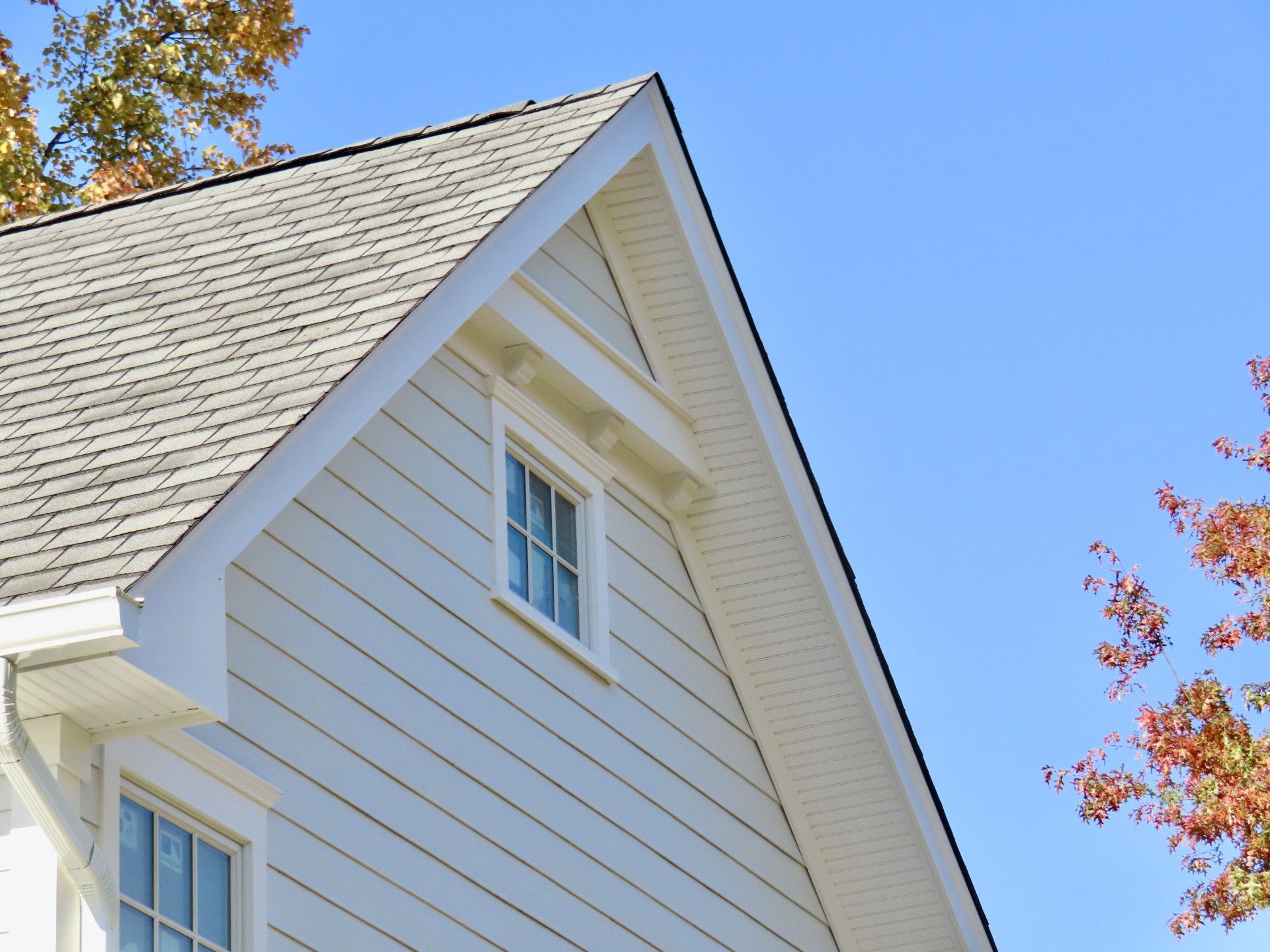 A white house with a gray roof and a window
