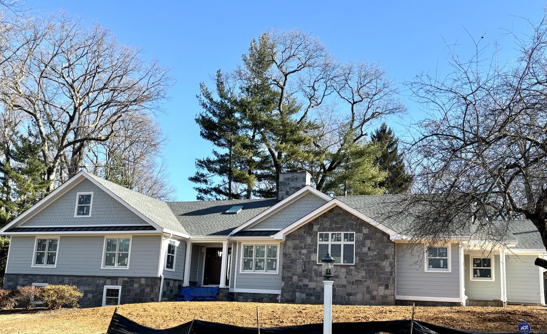 A large house with a lot of windows and trees in the background.