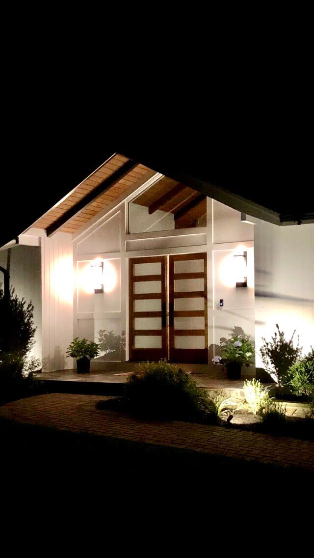 The front door of a house is lit up at night.