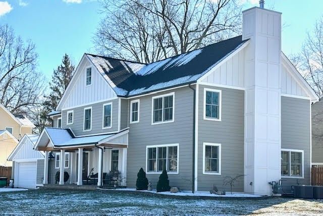 A large house with a lot of windows and a chimney on the roof.